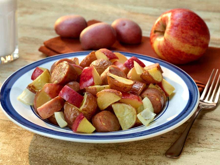 Roasted potatoes with apples and chicken sausage on a plate by the Colorado Potato Administrative Committee